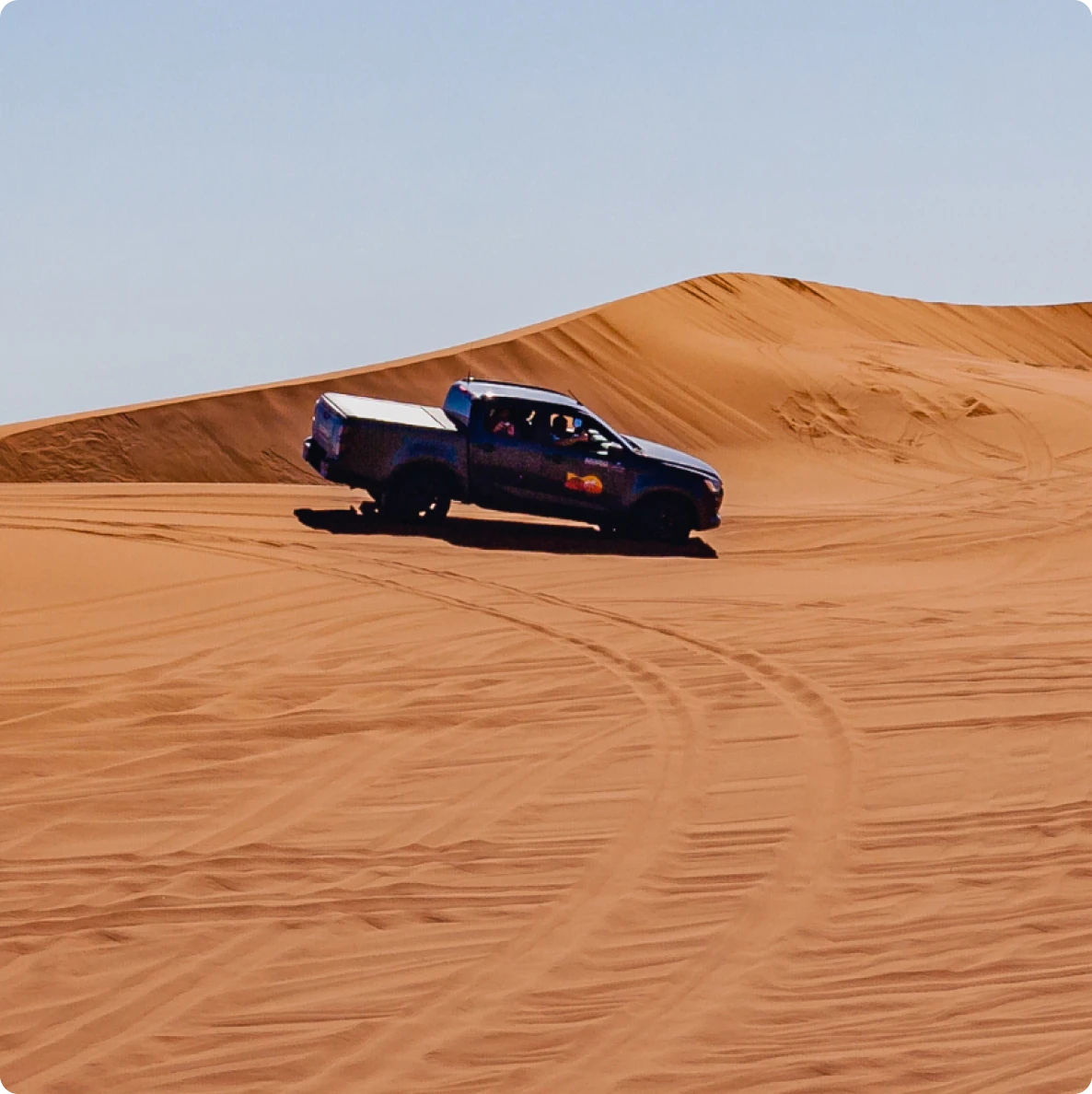 Truck driving on desert sand dunes